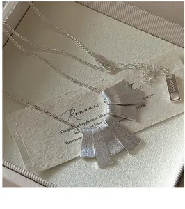 Macro detail of S925 sterling silver necklace featuring brushed texture and tassel plates