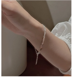 Close-up of S925 sterling silver woven twist chain bracelet worn on a woman's wrist