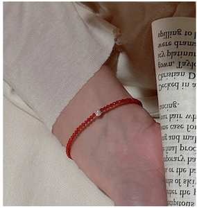 Gros plan d'un bracelet en argent S925 avec perles rouges facettées et détail scintillant
