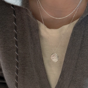 Layered S925 silver necklace set with tennis chain and hammered coin pendant on a model
