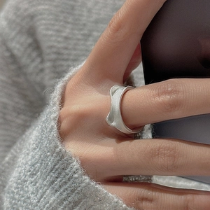 Minimalist S925 sterling silver cat ear ring with irregular matte wave texture on finger
