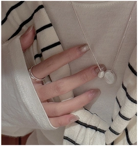 Close-up of minimalist S925 silver necklace and ring set with brushed metal texture pendants