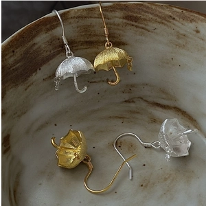 Detail shot of vintage S925 sterling silver umbrella earrings with matte finish in a bowl