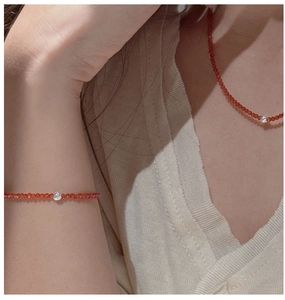 Détail d'un ensemble collier et bracelet en perles rouges porté par un mannequin