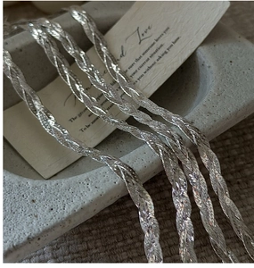 Close-up of polished S925 silver woven chain bracelet with flat scale-like links