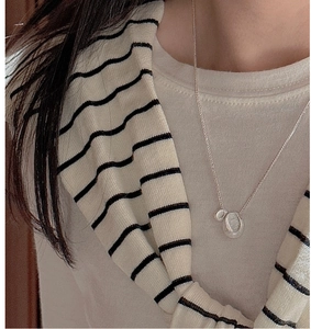 Detail of silver S925 necklace with dual oval pendants showing brushed metal texture on neck