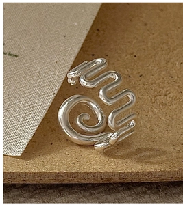 Macro detail of S925 sterling silver ring with unique spiral and wavy line design