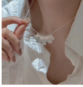 Detail of layered S925 sterling silver brushed texture pendant on a choker necklace