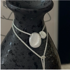 Detail of S925 silver necklace featuring brushed matte pebble pendants on wheat chain