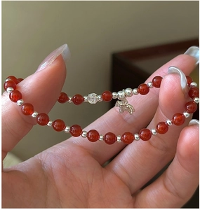 Vue détaillée du bracelet en agate rouge avec pendentifs porte-bonheur en argent S925