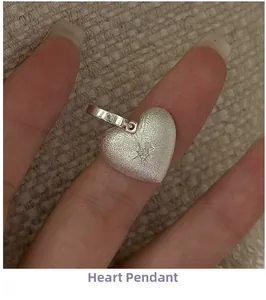 Macro detail of S925 sterling silver heart pendant with brushed texture and star engraving