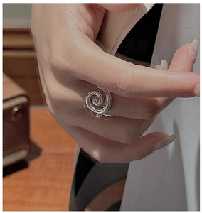 Macro shot of S925 sterling silver spiral ring showing modern fluid art texture