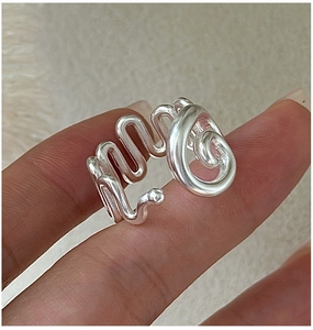 Detailed view of an S925 sterling silver ring with irregular wave texture on finger
