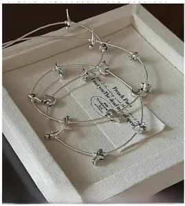 Detail showing retro silver elephant and star charms on a beaded long sweater necklace