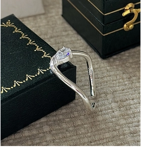 Macro view of S925 sterling silver ring with marquise-cut zircon and wave band detail
