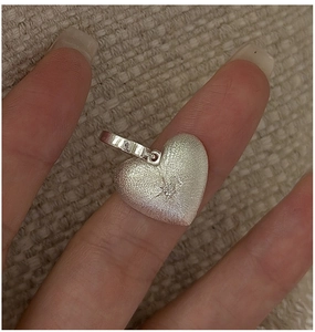 Macro view of matte S925 sterling silver heart pendant with textured finish and stone