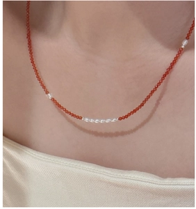 Detailed close-up of S925 silver necklace with red spinel beads and white pearls on neck