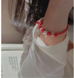 Close-up of red braided rope bracelet with S925 silver mouse pendant and beads
