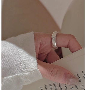 Nahaufnahme eines matten S925 Sterling Silber Knotenrings am Finger mit einem Buch
