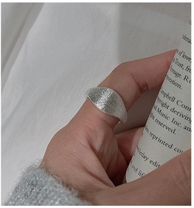 Close-up of a wide minimalist silver ring with a unique brushed matte texture finish