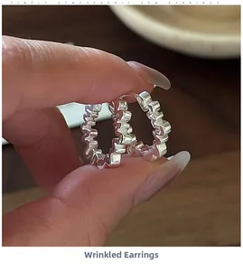Gros plan sur les créoles en argent sterling S925 avec texture froissée irrégulière