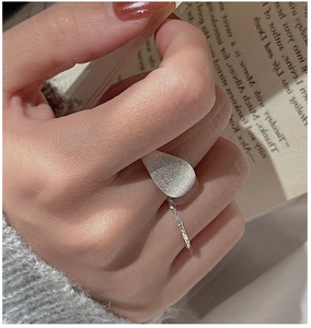 Detailed macro view of S925 sterling silver brushed matte drop-shaped ring and rope band