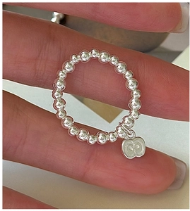 Detailed close-up of S925 sterling silver beaded ring with white apple charm pendant