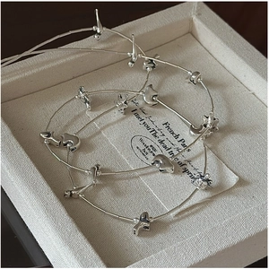 Detail of silver S925 sweater chain with animal and celestial charms in a jewelry box