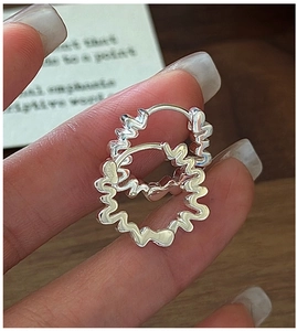 Vue macro des boucles d'oreilles créoles en argent S925 avec texture ondulée