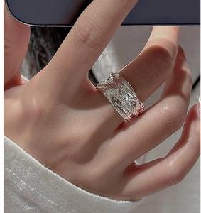 Close-up of S925 sterling silver ring with molten lava texture on hand with knitwear