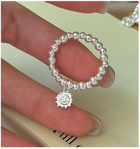 Close-up of S925 sterling silver beaded stretch ring with a sun smiley face pendant