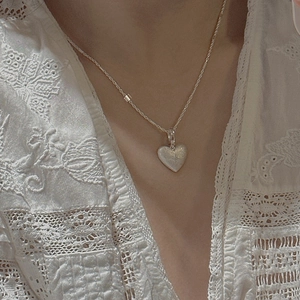 Vintage S925 sterling silver heart pendant with matte texture on a lace dress