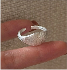 Macro shot of minimalist S925 sterling silver ring with matte frosted texture and open band