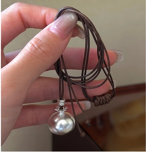 Dettaglio del ciondolo kaki in argento con collana in cordino di cuoio marrone regolabile