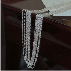 Gros plan d'un collier multicouche en argent S925 avec texture ondulée sur bois