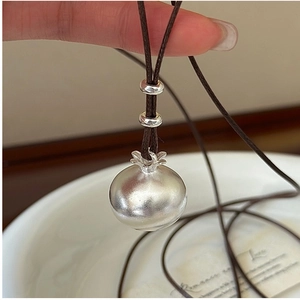 Dettaglio del ciondolo in argento sterling S925 con finitura opaca su collana di cuoio