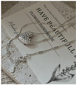 Dettaglio della collana con pendente a cuore in argento sterling S925 e motivi traforati