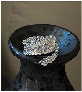 Detailed close-up of S925 sterling silver feather ring with sparkling zircon stones