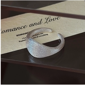 Macro detail of S925 sterling silver ring with brushed matte finish on a mirror surface
