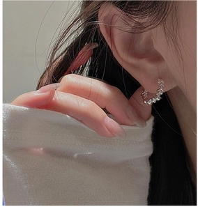 Gros plan détaillé de boucles d'oreilles en argent avec texture ondulée vintage