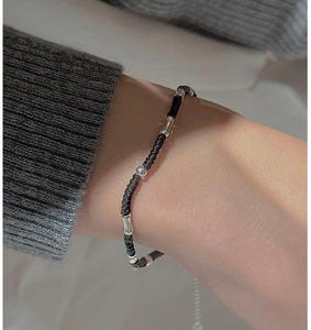 Detailed view of handmade woven black cord bracelet with silver beads and bamboo tubes