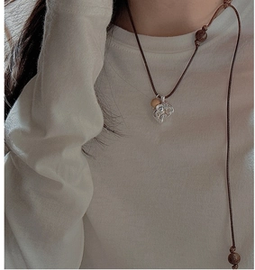 Detail of S925 silver elephant pendant with vintage texture and wooden bead cord