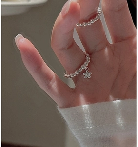 Detailed close-up of a beaded S925 sterling silver ring with a delicate flower charm