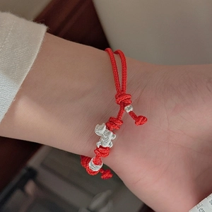 Red cord bracelet with S925 sterling silver Pixiu charm and beads on a model's wrist