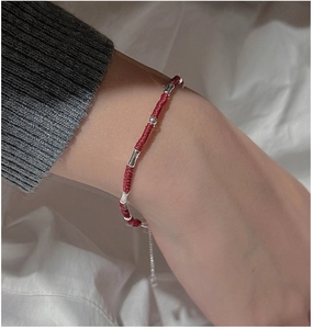 Detailed close-up of S925 sterling silver bamboo beads on a hand-woven red rope bracelet