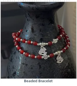 Détail macro d'un bracelet en perles d'agate rouge avec breloques de cheval et de pièce