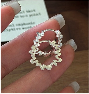 Vue rapprochée des boucles d'oreilles vagues en argent S925 avec finition polie brillante