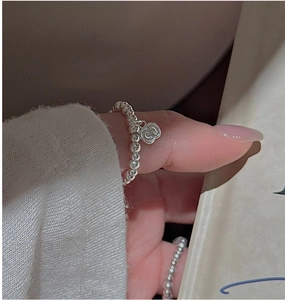 Detail of S925 sterling silver beaded ring with a textured small apple pendant charm