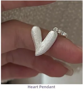 Vue rapprochée d'un pendentif cœur en argent mat avec une finition brossée