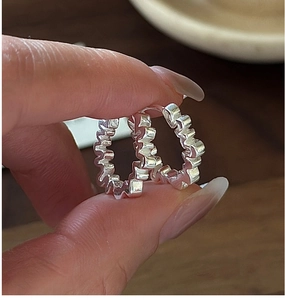 Gros plan détaillé de boucles d'oreilles créoles S925 en argent à texture ondulée vintage